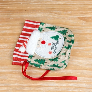 Linen Christmas drawstring gift bag with Santa Claus applique on a wooden surface