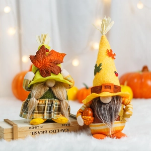 Harvest gnome couple plush decor with maple leaves and acorns on a cozy wooden crate