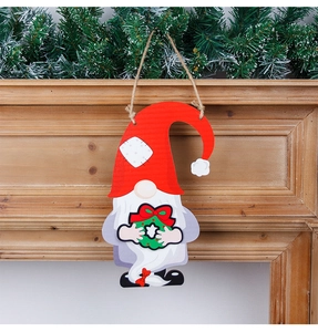 Detail of DIY wooden gnome door hanger with a green Christmas wreath on fireplace
