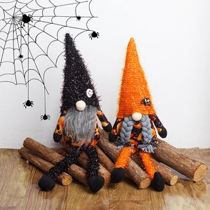 Pair of Halloween faceless gnomes with pumpkin patterns sitting on a rustic wooden stump