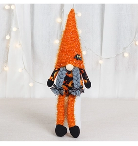 Detailed view of an orange Halloween gnome plush with bat decor and long braided hair