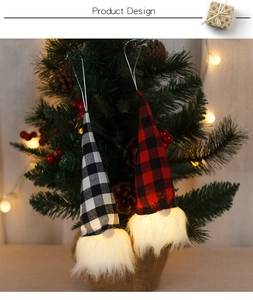Close-up of LED glowing Christmas gnomes with red and black plaid hats on a tree