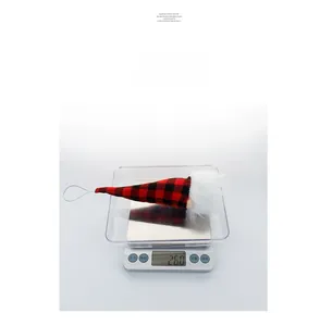 Detailed weight measurement of a Christmas gnome ornament with red plaid hat on a digital scale
