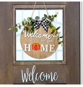 Detail eines runden Holztürschilds mit 3D-Text Welcome To Our Home und Geschenk-Icon