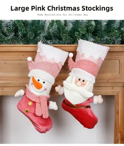 Detailed close-up of pink Santa and Snowman Christmas stockings hanging on a wooden mantel