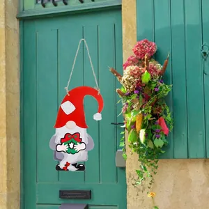 DIY wooden Christmas gnome door sign with red hat and hanging wreath decoration