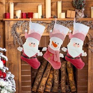 Three-piece Christmas stocking set with Santa and Snowman hanging on wooden fireplace