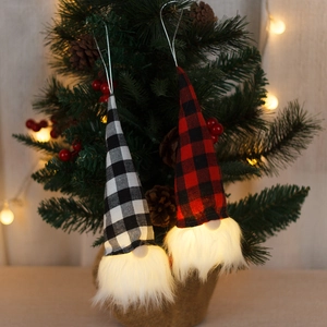 Lighted Christmas gnome ornaments with red and black checkered patterns on a Xmas tree