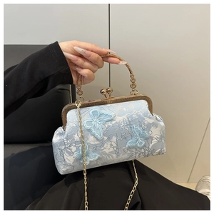 Détail du sac coquillage bleu clair avec broderie papillon 3D et poignée dorée vintage