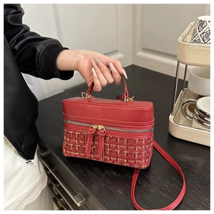Detail of red tweed patchwork box bag featuring gold hardware and dual zippers