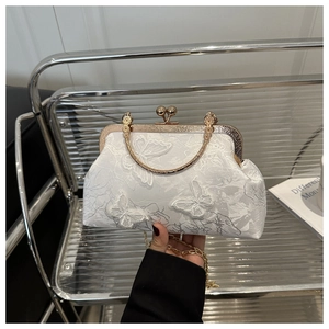 Détail de sac de soirée blanc avec broderie papillon 3D et poignée en métal doré