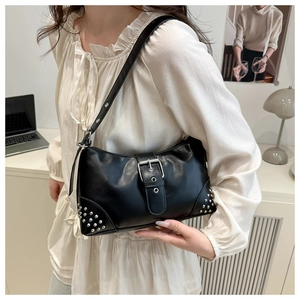 Detail of vintage black shoulder bag with silver rivets and decorative buckle on the side