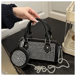 Detail of black cylindrical handbag with silver studs, chain strap and round coin purse