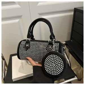 Détail du sac cylindrique noir avec rivets argentés et son petit porte-monnaie rond
