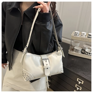 Detail of white vintage shoulder bag with silver rivets and metal buckle styling