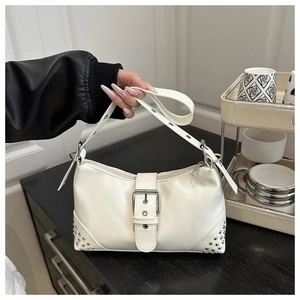 Detail view of white underarm bag with silver studs and adjustable metal eyelet strap