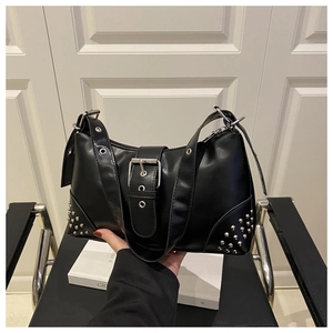 Detail view of black punk style shoulder bag with silver rivets and large buckle strap