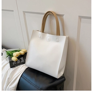 Detail of elegant cream tote bag with brown handles, tulip and book in lifestyle setting