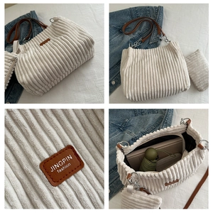 Detail view of white corduroy tote bag showing soft ribbed texture and leather logo patch