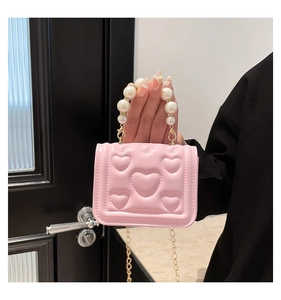 Close-up of pink heart-quilted PU leather bag featuring a large pearl handle and gold chain