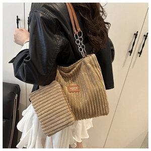 Detail of khaki corduroy tote and pouch set with chain strap and leather logo patch