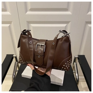 Detail of dark brown retro shoulder bag with silver studs and eyelet strap buckle