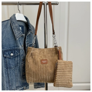 Close-up of corduroy tote bag set with leather straps and silver chain details