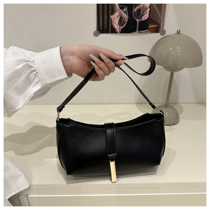 Detail of matte black PU leather shoulder bag with elegant gold bar metal fastener