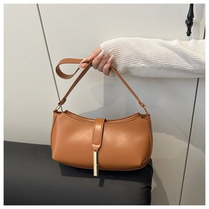 Detailed close-up of caramel brown PU leather underarm bag with gold metal buckle