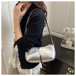 Close-up of a metallic silver PU leather underarm bag featuring a sleek vertical buckle strap