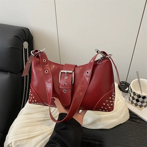 Chic red crescent shoulder bag with silver buckle and rivets on white backdrop