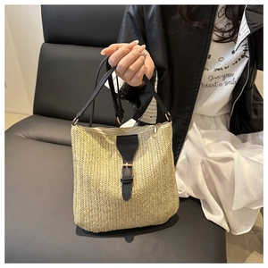 Detailed close-up of V-shaped straw weave texture with black leather strap and buckle