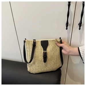Minimalist straw crossbody bag with contrast black strap and chic woven texture detail