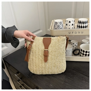 Detailed macro shot of beige straw weaving texture with brown faux leather strap on handbag