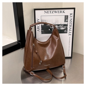 Close-up of vintage brown leather tote bag with tassel zipper and fashion logo