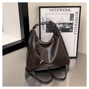 Macro shot of dark brown matte PU leather tote bag with FASHION & BAGS text on silver table