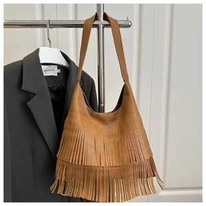 Gros plan sur un sac hobo en cuir marron avec double couche de franges et texture fine