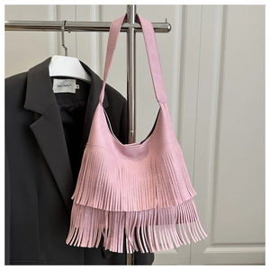 Détail du sac hobo rose en cuir grainé avec de longues franges et des finitions argentées