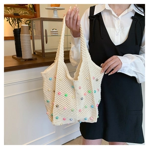 Close-up of beige woven crochet tote bag featuring colorful faux pearl beads detail