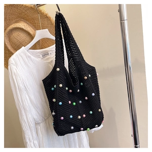 Detail of black hollow knit tote bag featuring vibrant colorful pearl embellishments