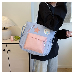 Detail der hellblauen Segeltuchtasche mit rosa Reißverschlusstasche und Sternen-Patch