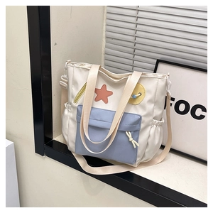 Detail of color-block tote bag with playful patches, adjustable strap and side pocket