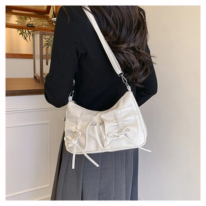 Détail du sac hobo blanc cassé avec poches à nœuds papillon et finition cuir PU lisse