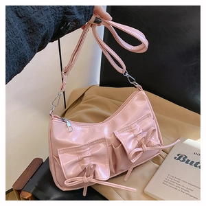 Détail d'un sac sous les bras rose brillant avec deux poches avant et des nœuds