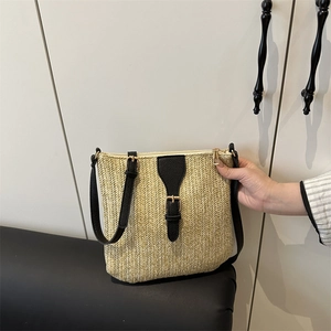 Straw shoulder bag with black leather flap and adjustable strap for summer beach vacations