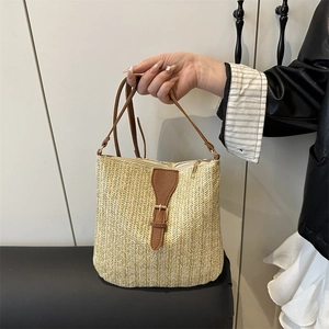 Hand-woven straw crossbody bag with brown leather accents for summer beach vacations