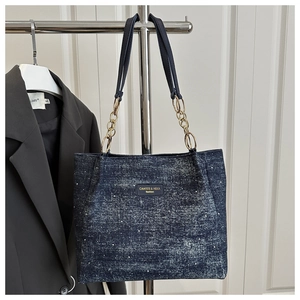 Détail du cabas en denim bleu marine avec strass scintillants et chaîne dorée en cuir