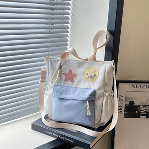 Waterproof nylon tote bag with light blue pocket and adjustable strap for students