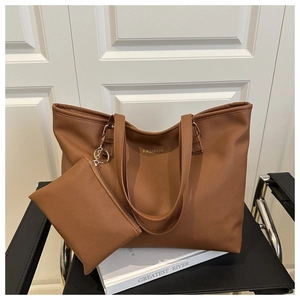 Detail of brown litchi pattern leather tote bag with gold fashion logo and small pouch