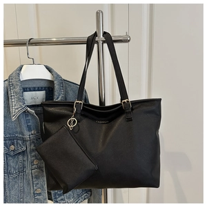 Detail of black Saffiano leather tote bag set with gold hardware and FASHION logo